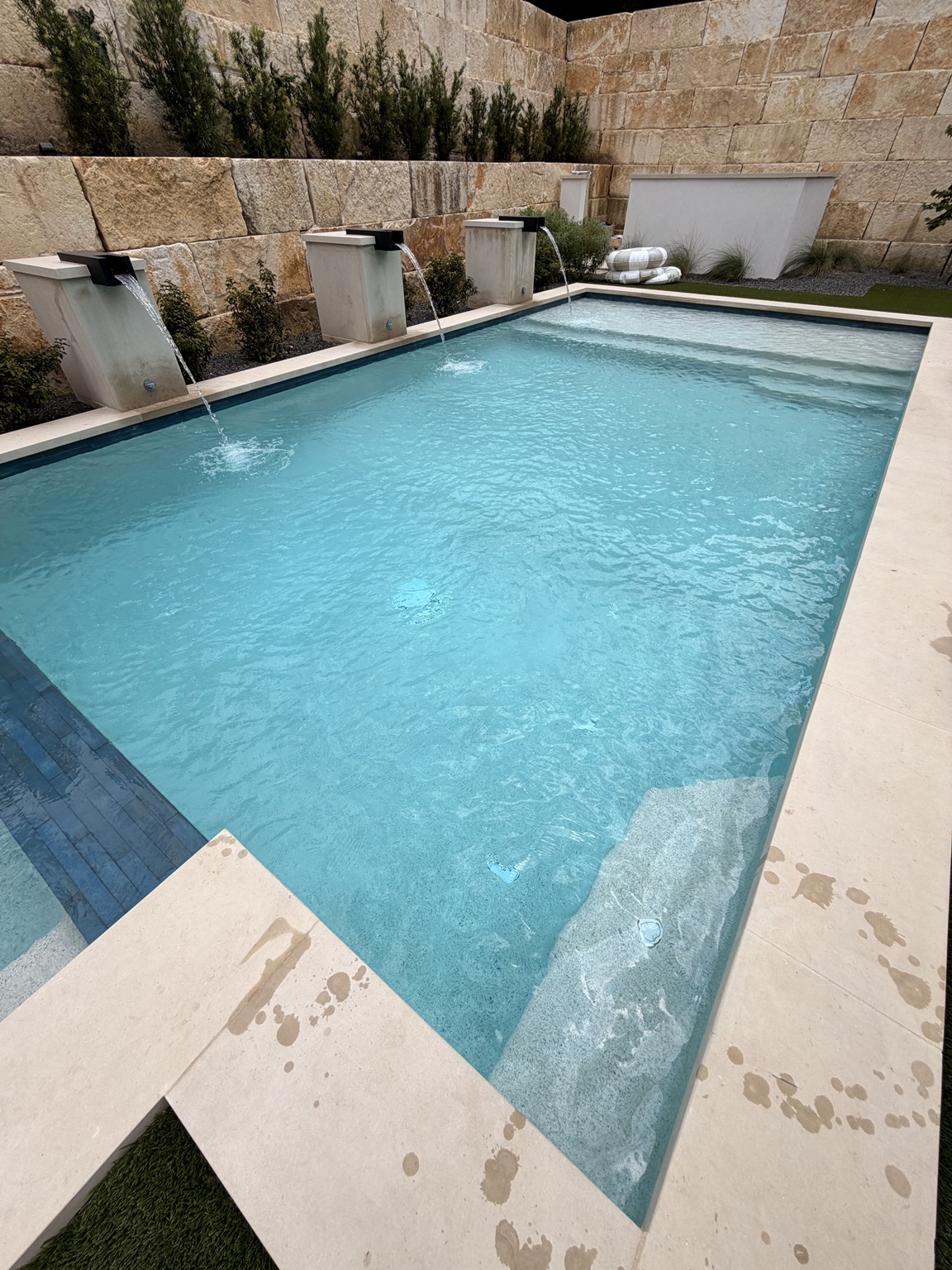 Modern pool with clear blue water and waterfalls