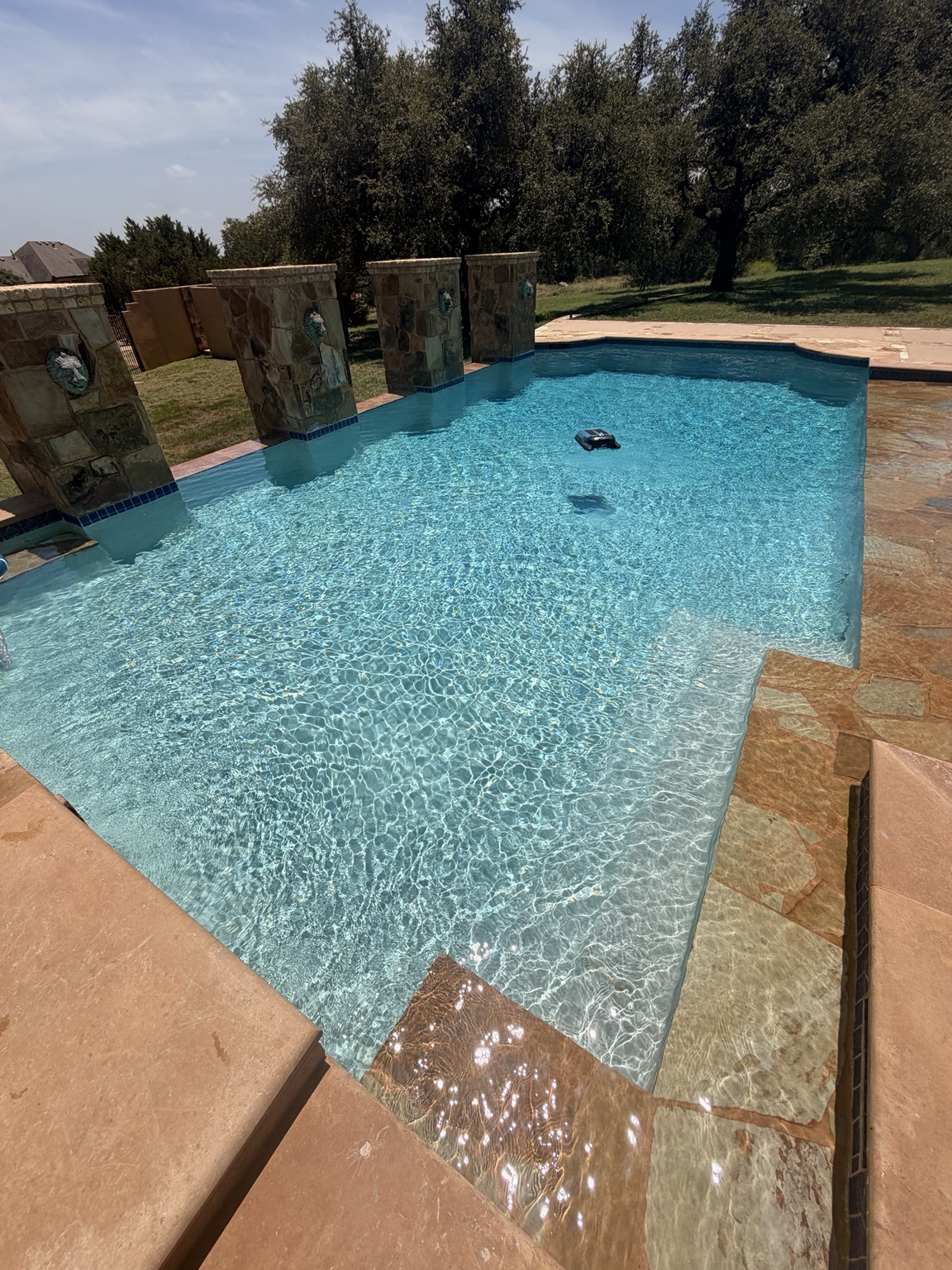 Clear residential pool with stone water features